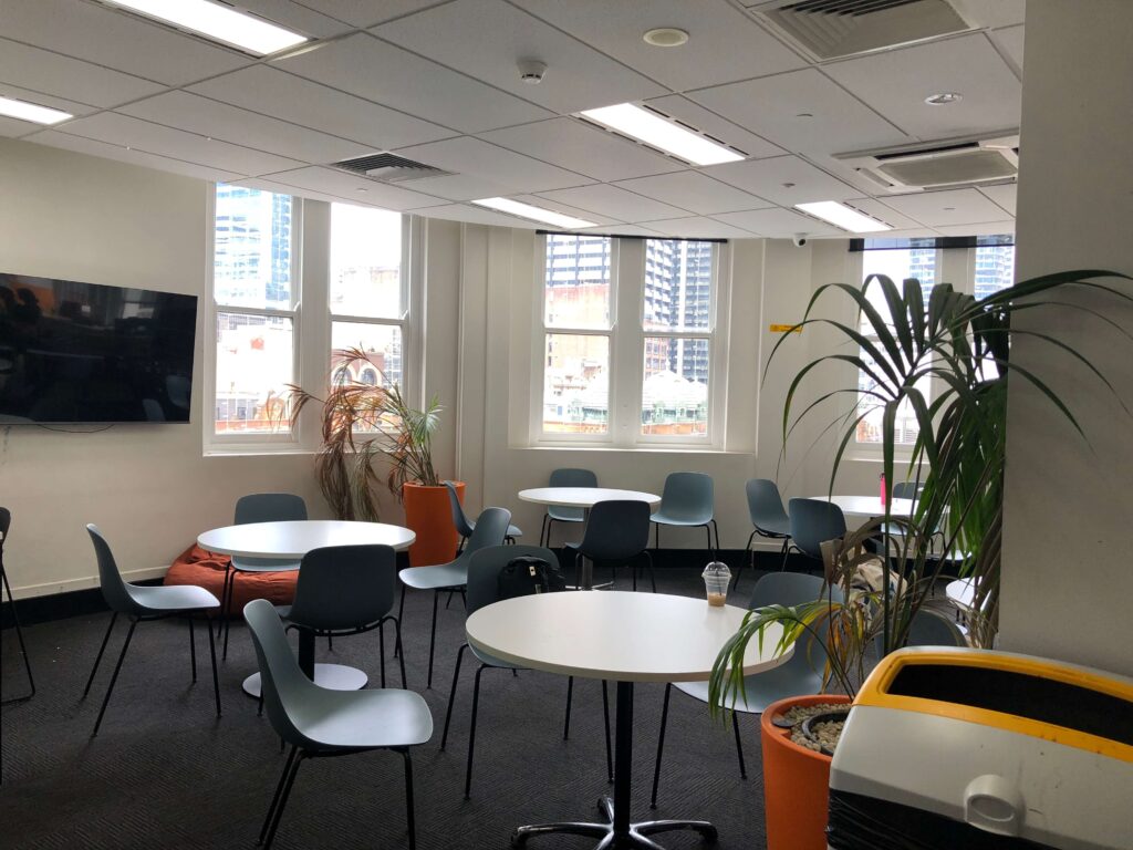 ILSC Sydneyの学生ラウンジ（窓際にテーブルとイスが並ぶリラックススペース）