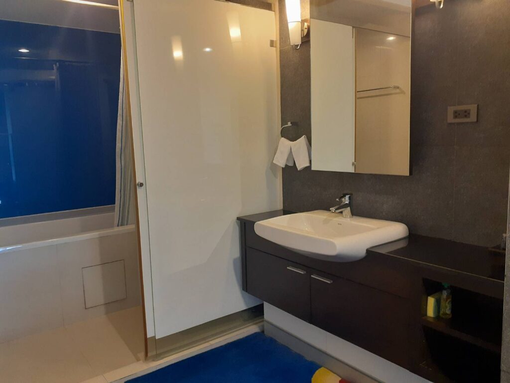 IHバンコクが手配するMona Suiteのバスルームで、洗面台と浴槽がある室内