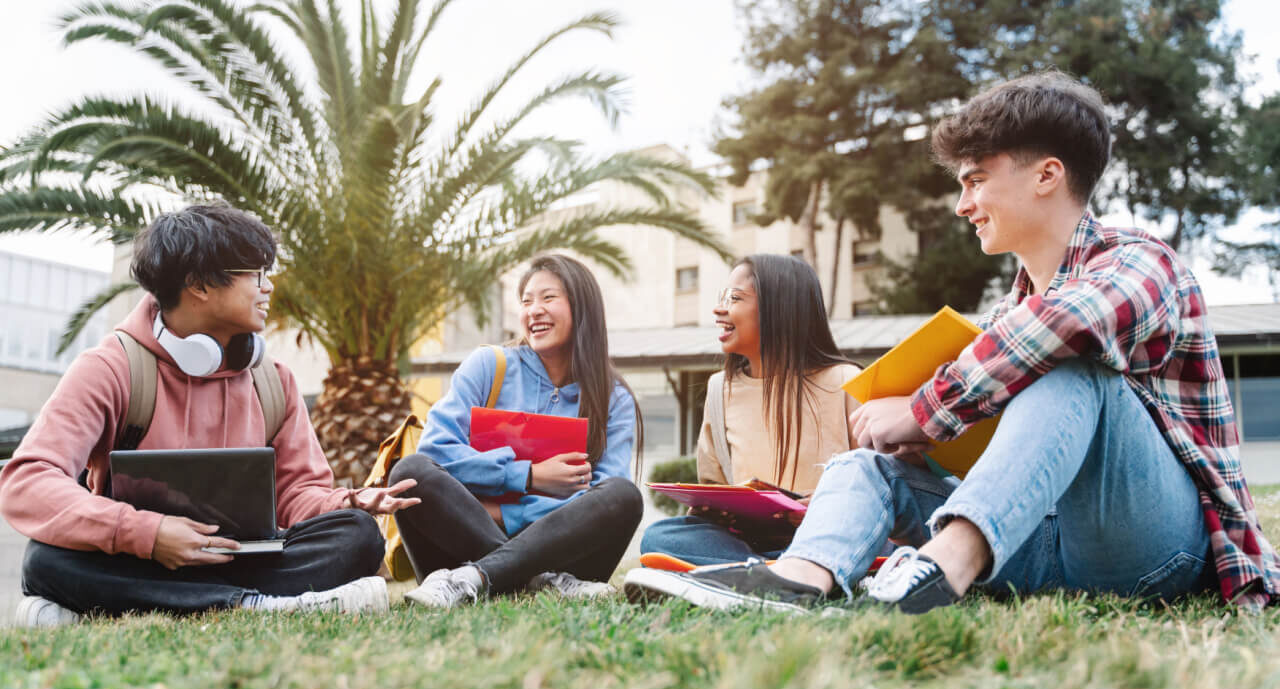 芝生の上で談笑する留学生たち