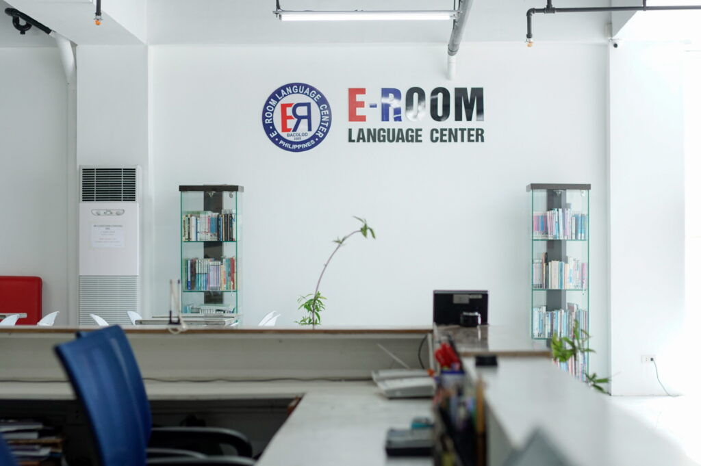 E-ROOM Language Centerの受付カウンターと本棚(校舎内の事務エリア)