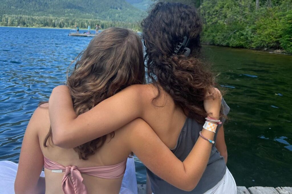 CESのカナダ・ジュニアプログラムで、湖のほとりに座り自然環境を体験している参加者の様子