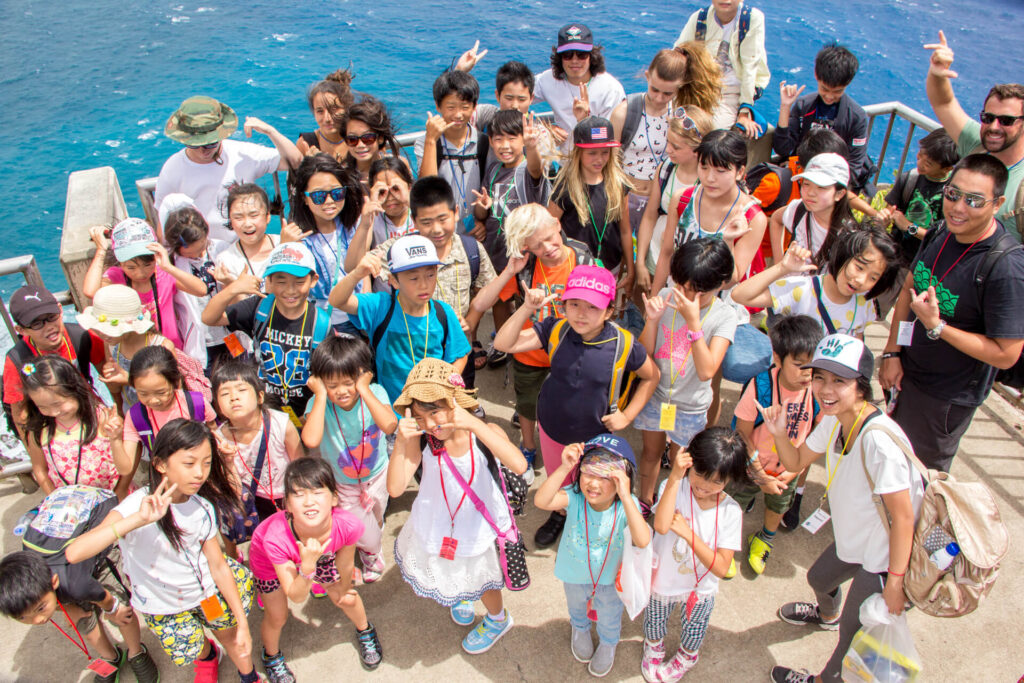 IIE HawaiiのKids & Teens Englishプログラムで、海を背景にグループでアクティビティを行う子どもたちの様子