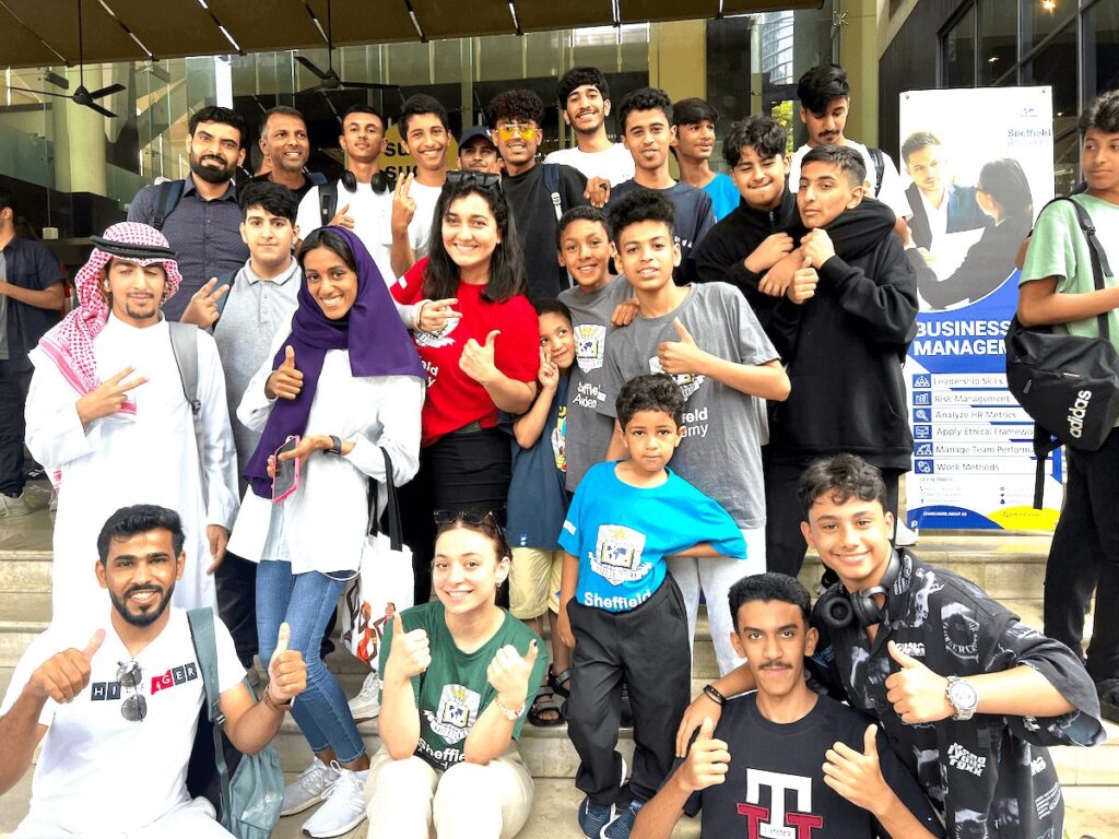 Sheffield Academyのサマーキャンプ参加者とスタッフが、校内エントランス前で撮影した集合写真