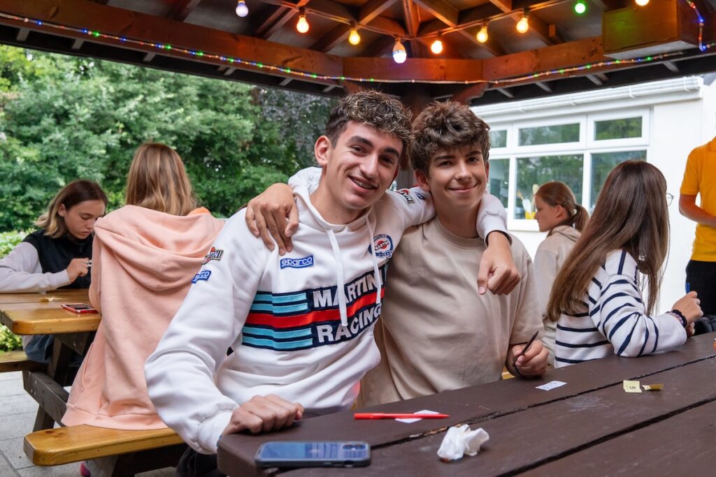 Alpadia TorquayのJuniorプログラムで、屋外のテーブルに集まり交流している参加者の様子